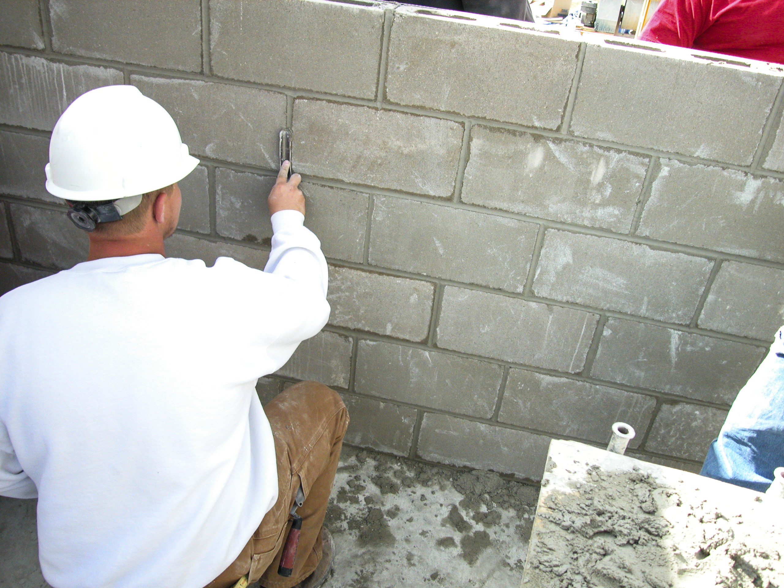 man tooling masonry joints with a brick jointer